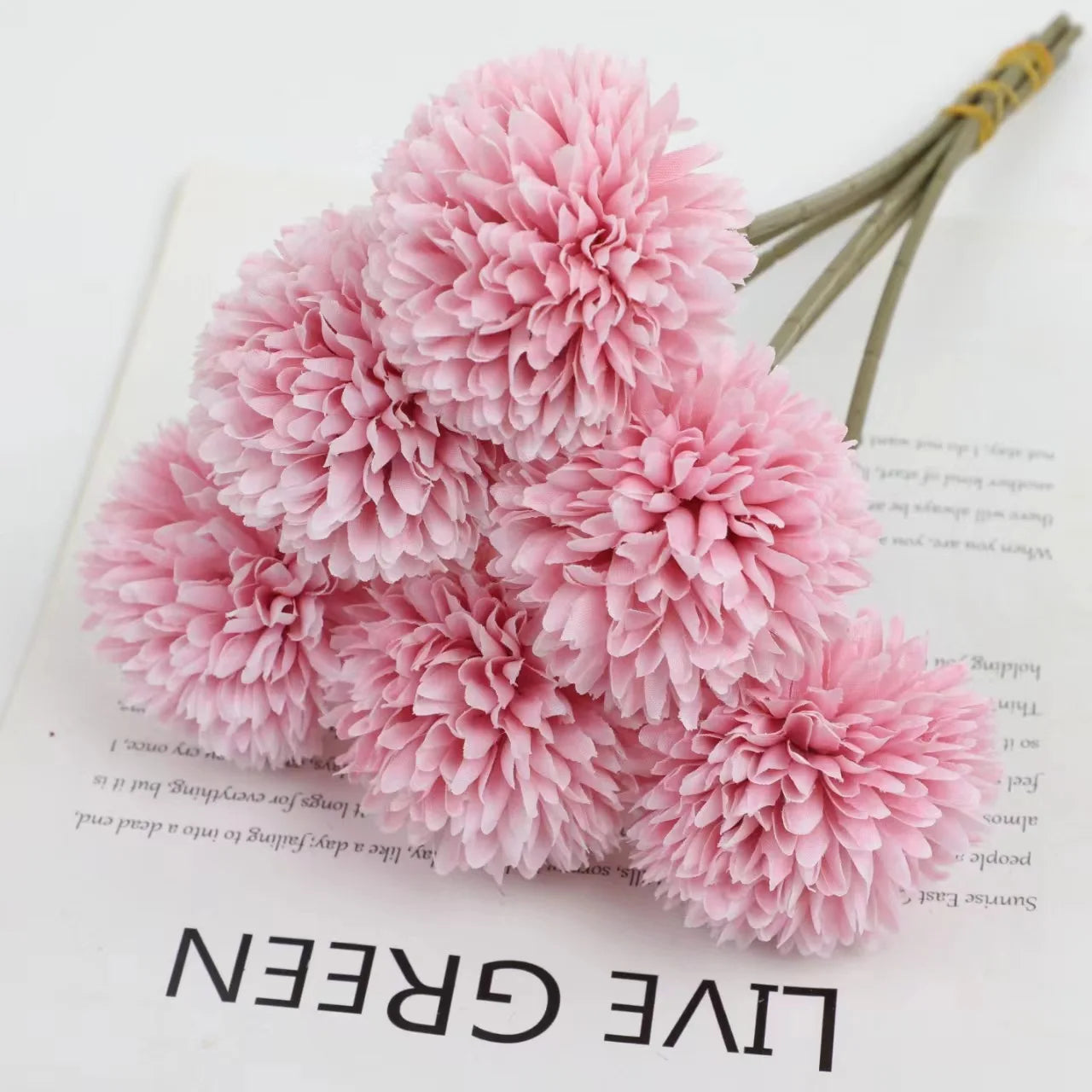 ramo de hortensias rosas sobre una hoja de papel con letras negaras que pone live green