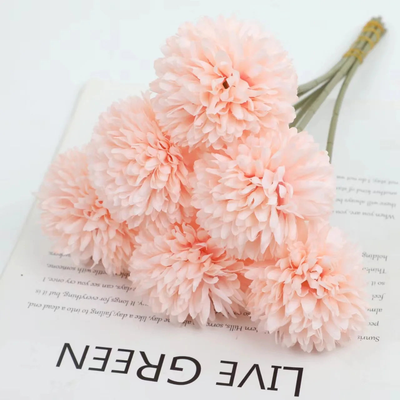 ramo de hortensias rosas sobre una hoja de papel con letras negras que pone live green